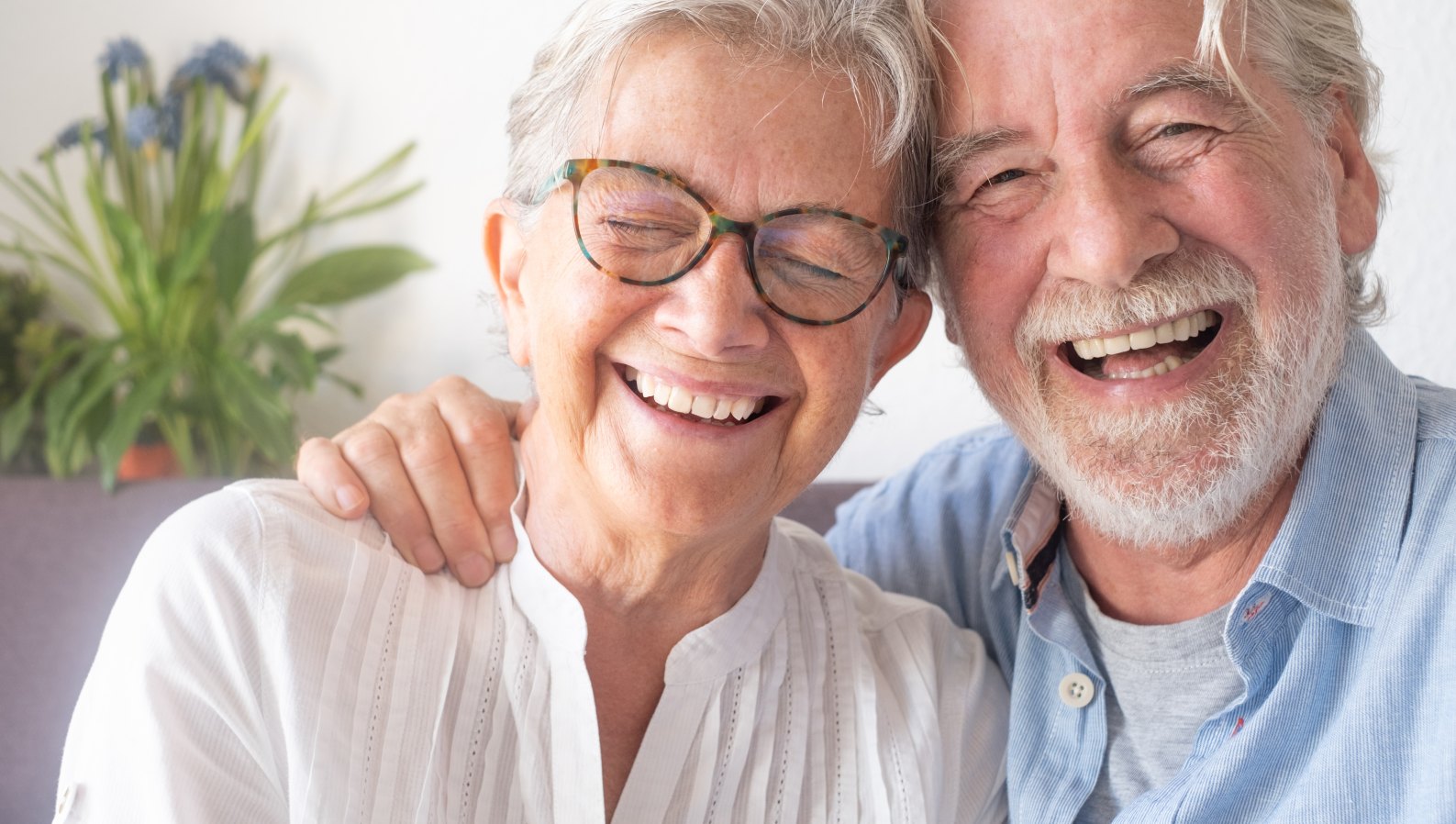 A happy senior couple relaxing at home, supported by the right caregiver
