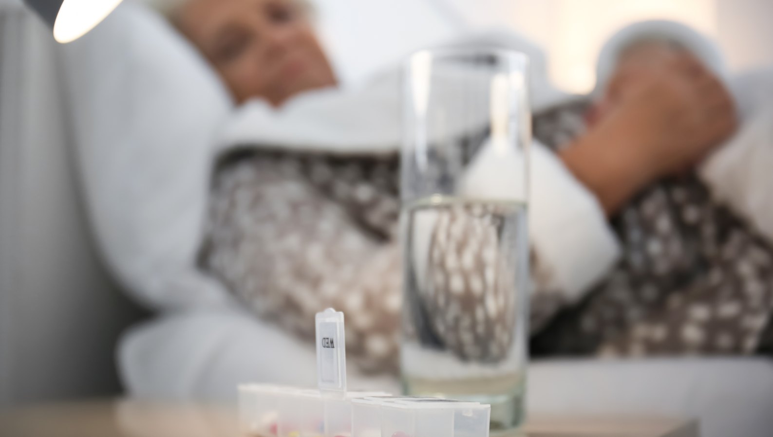 Medication and a glass of water on a table, supporting safe recovery