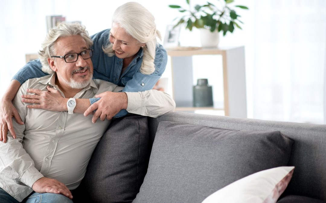 A content senior couple relaxing together in their living room at home